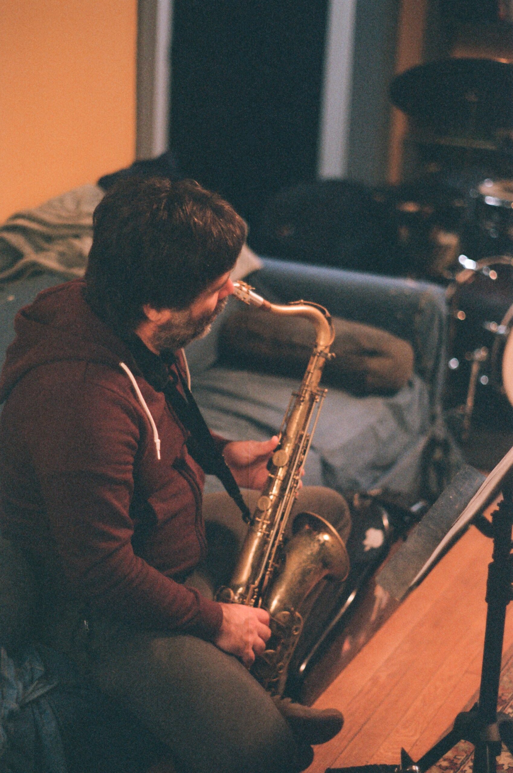 Person with saxophone sits on a blue couch
