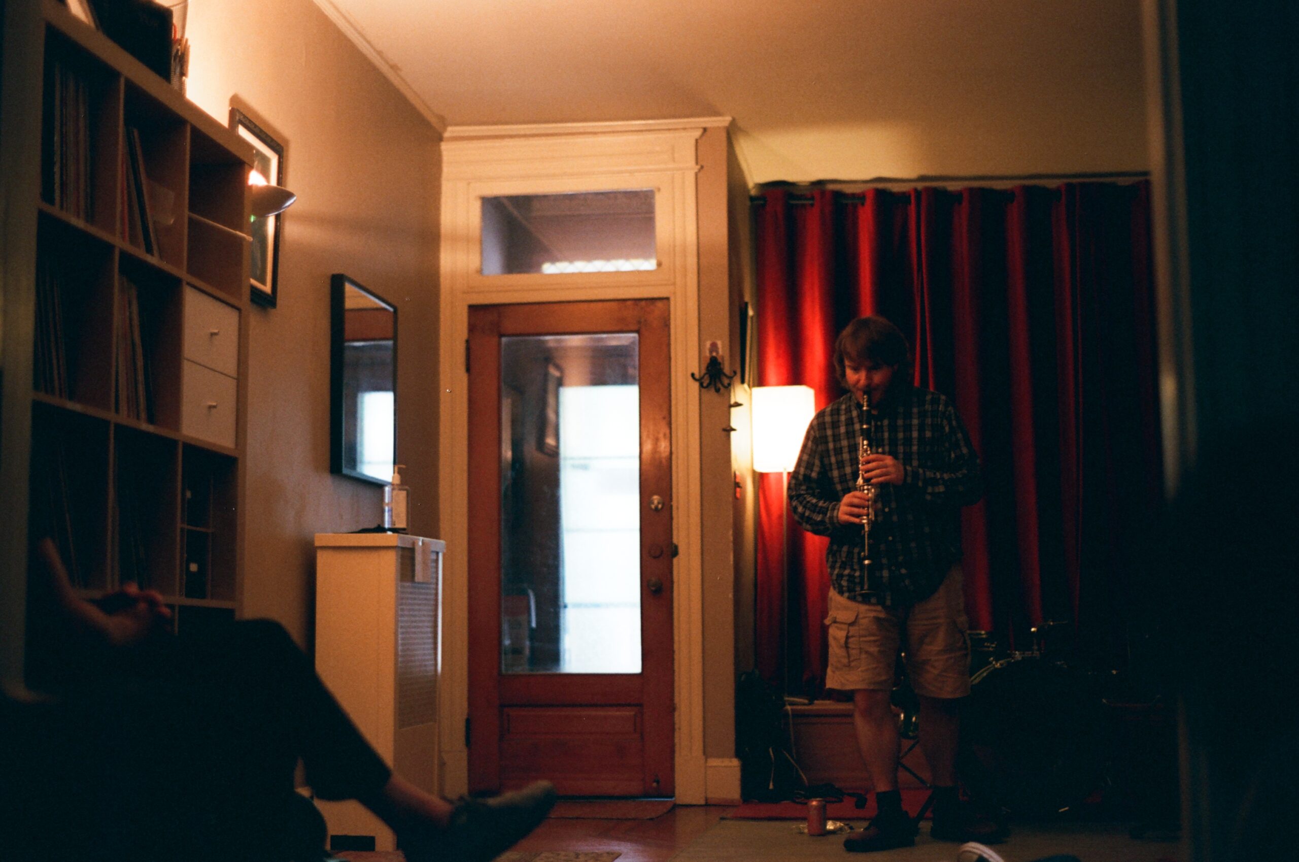 A clarinetist plays in front of red curtains