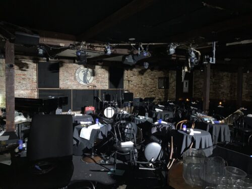 The inside of Blues Alley jazz club, with chairs strewn about and some damage visible to the ceiling.